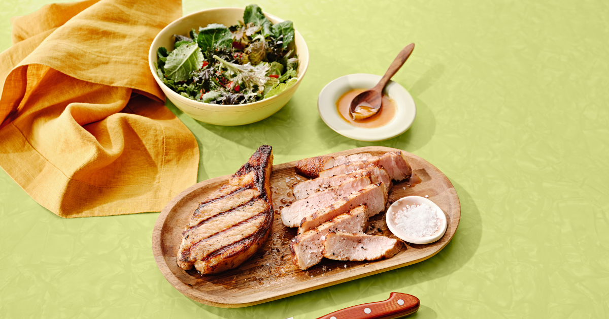 grilled pork chops and salad on the table